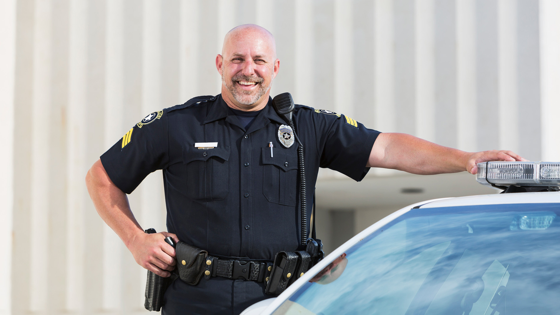 Happy Police Officer next to car